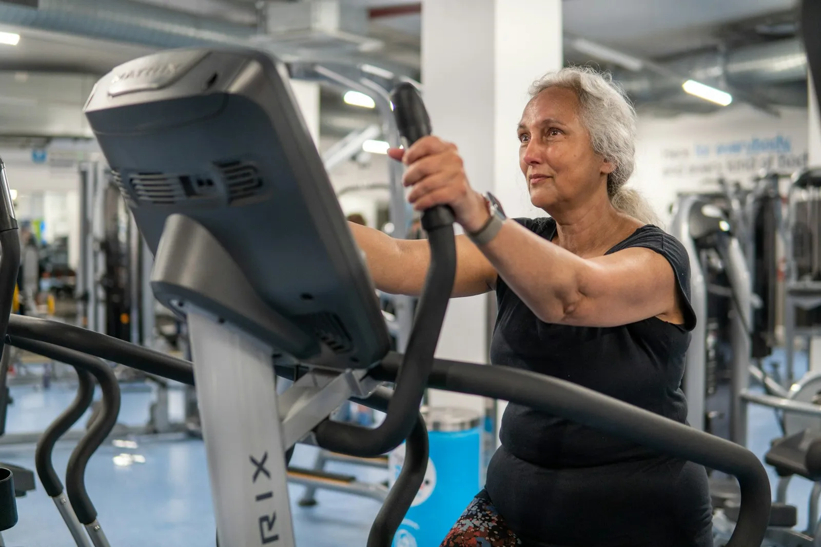 Mujer mayor haciendo ejercicio en bicicleta elíptica