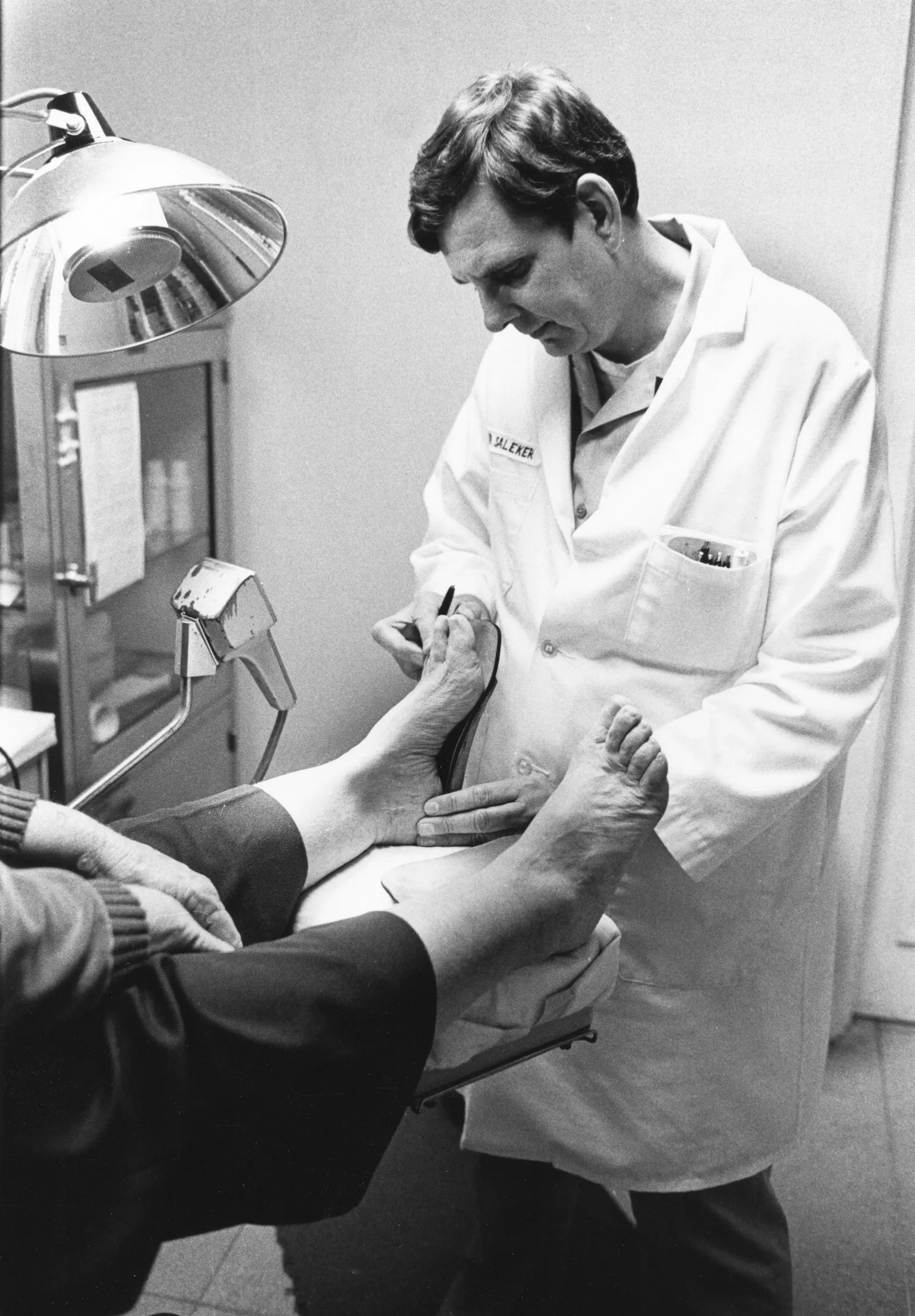 Médico examinando el pie y el tobillo de un paciente