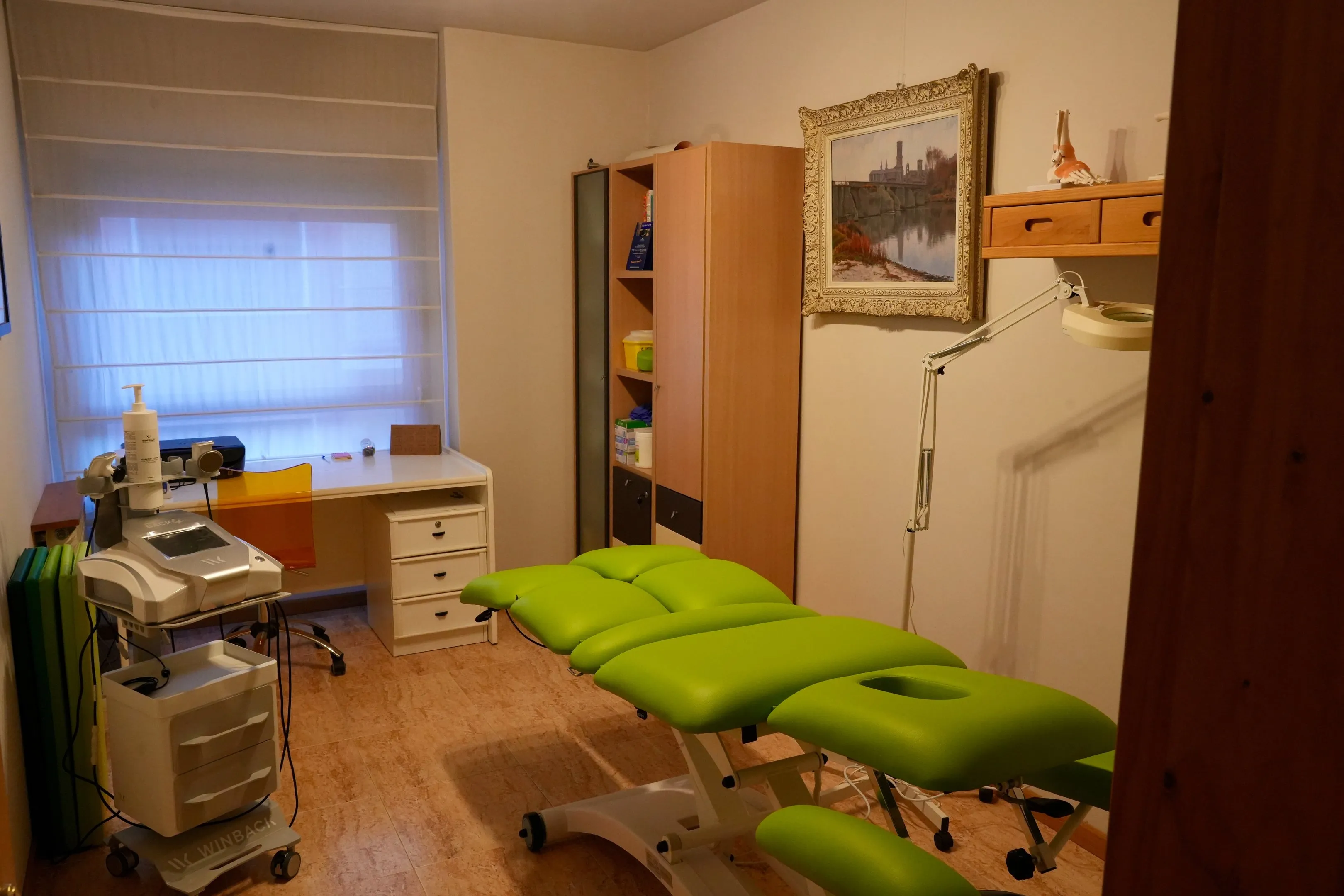 Sala de tratamiento de la clínica con camilla verde